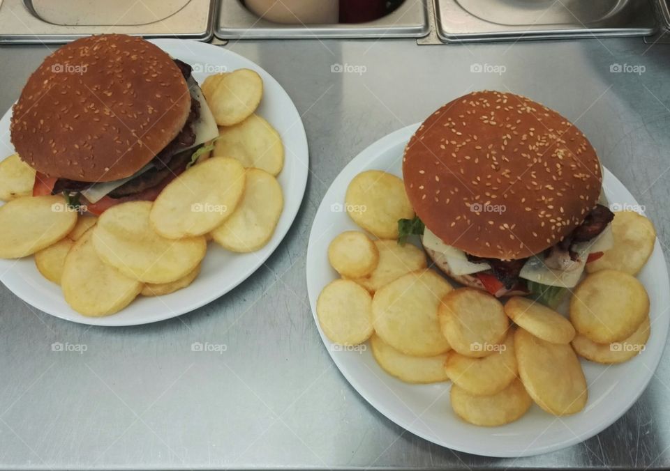 two burgers on plate with french fries