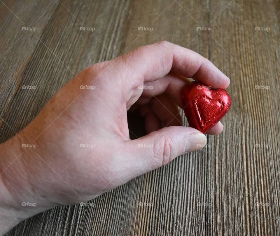 Hand holding heart shaped candy