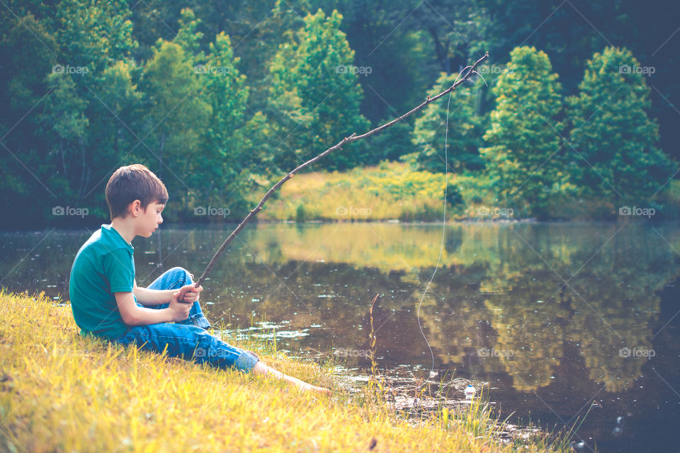 Young Boy Fishing in a Pond with Homemade Pole 4