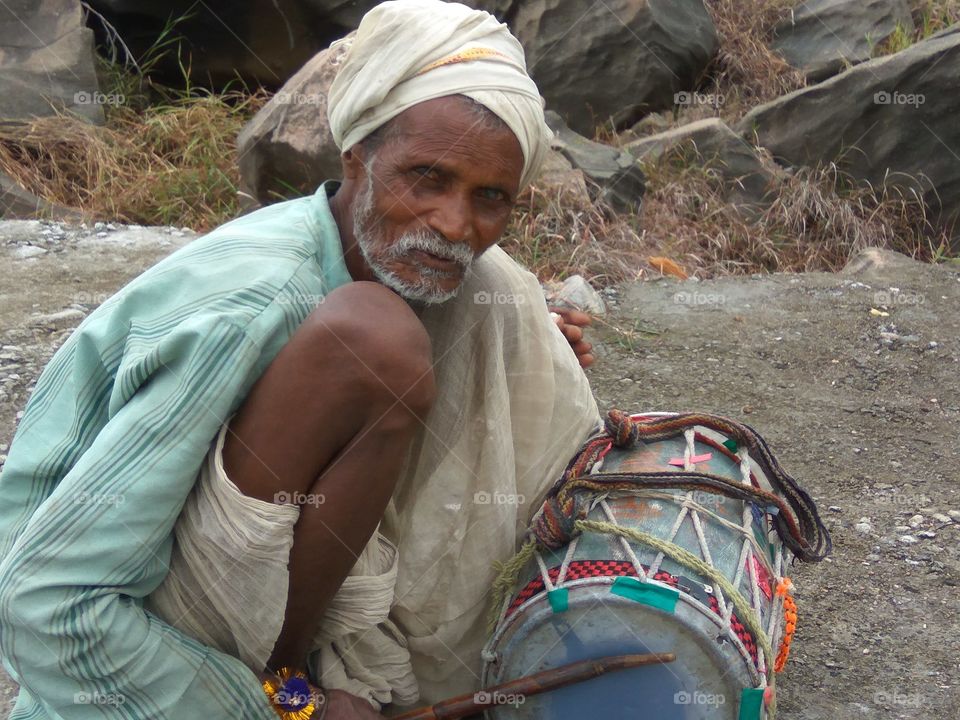 Indian old man playing drum