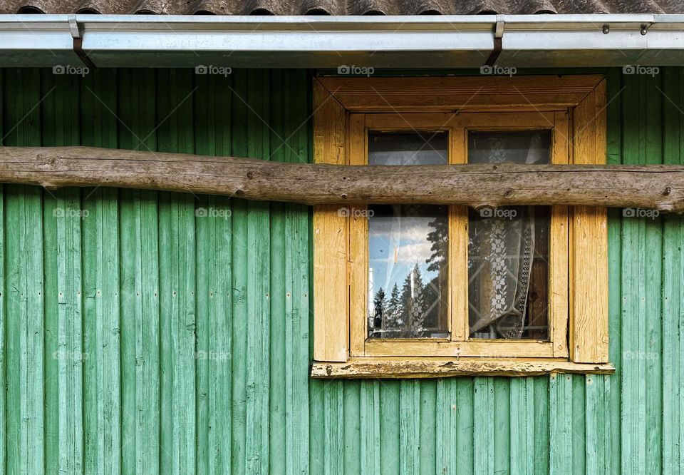 Old house in green walls and yellow window