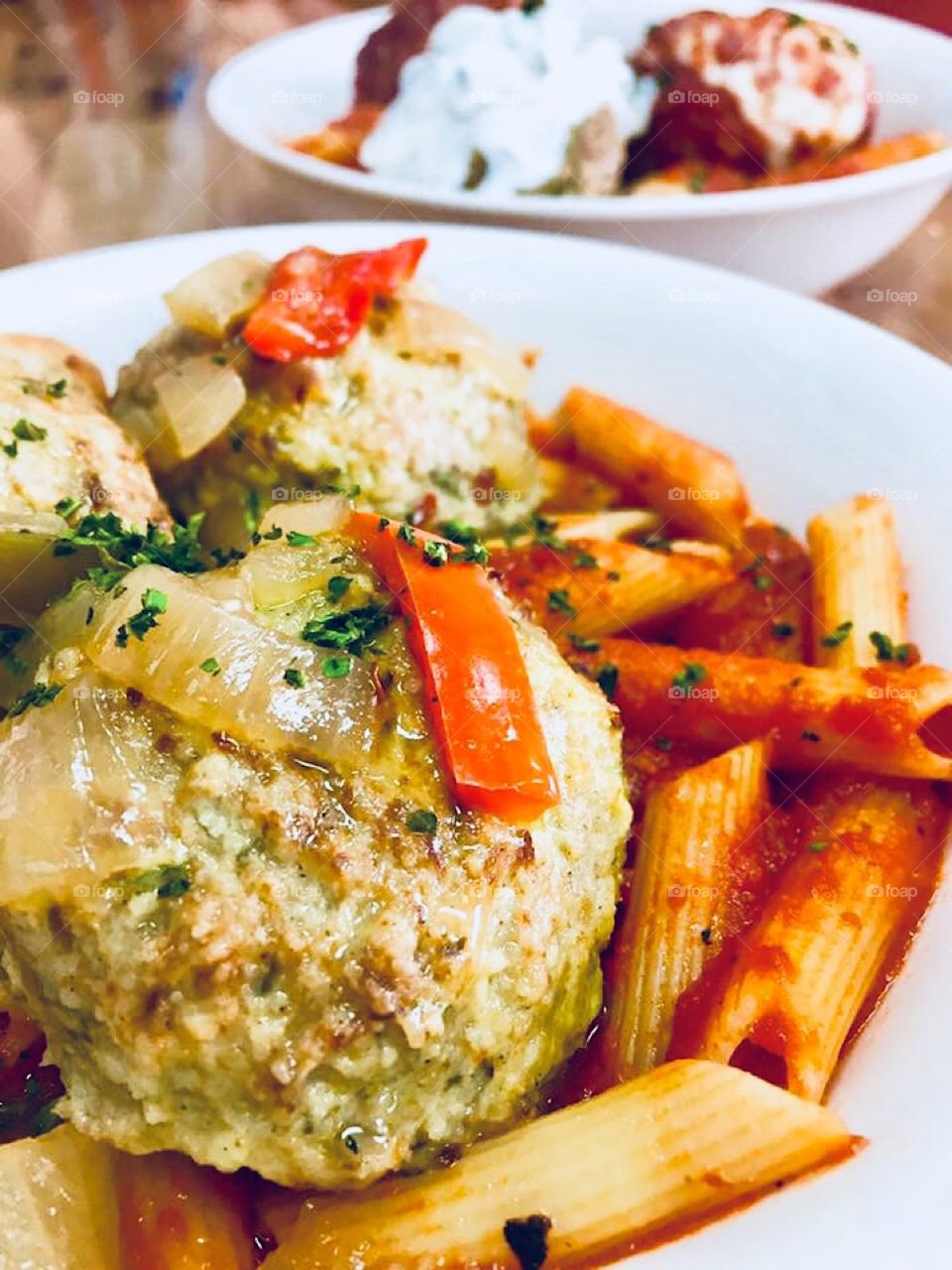 Italian meatballs and ziti with tomato sauce in a dish on the table.