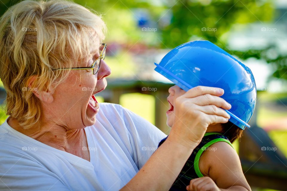 Grandmother goofs around with grandson on sunny day