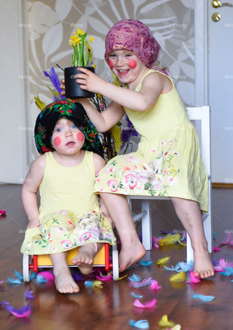 Two young sisters having fun infront of the camera with easter theme.