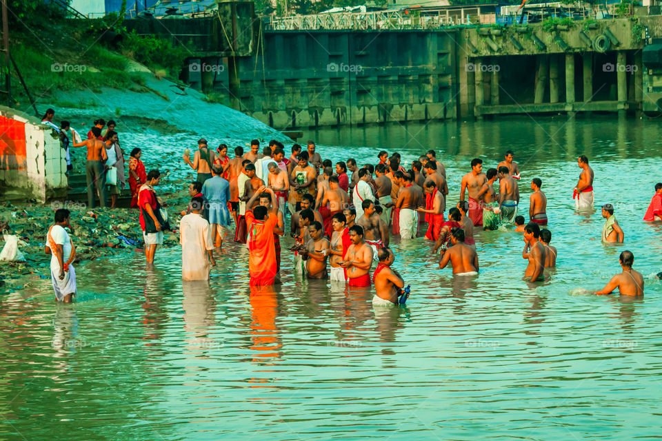 KOLKATA, INDIA - JANUARY 14, 2016: India family taking a bath on the water of Ganga during Kumbh Mela. Ganga water not even suitable for bathing, many toxic materials found: Report