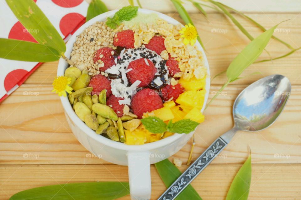 Fresh fruit smoothie bowl - raspberry,  nuts, mangoes,  cereal, seeds, mints