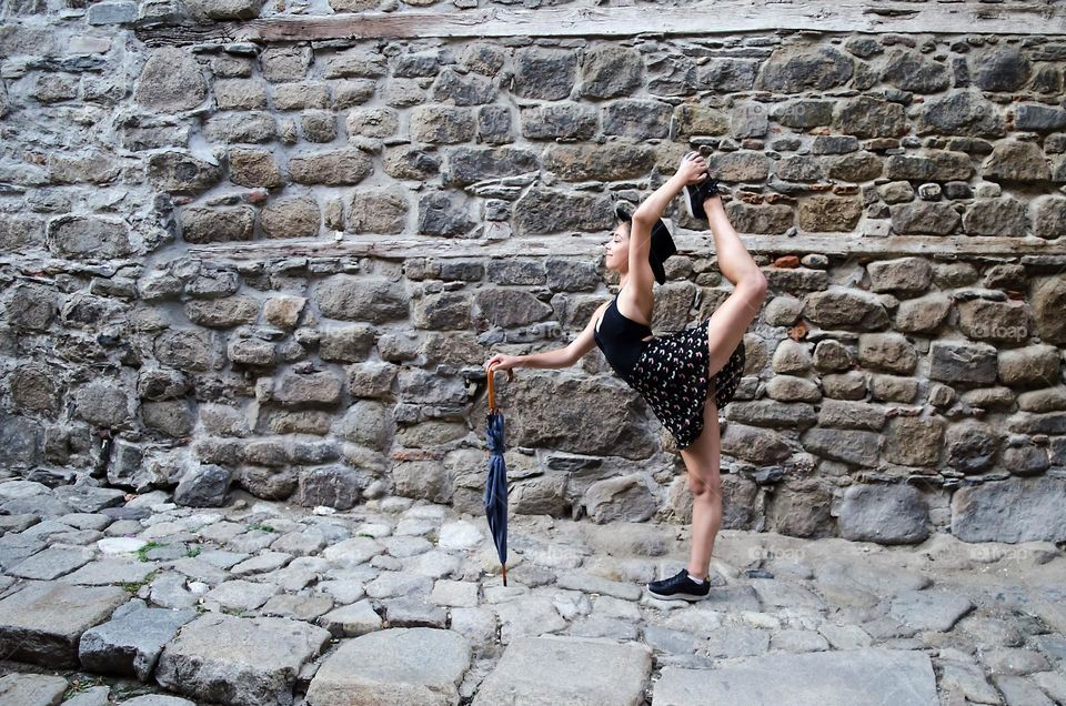 A girl with umbrella strikes a pose on the street