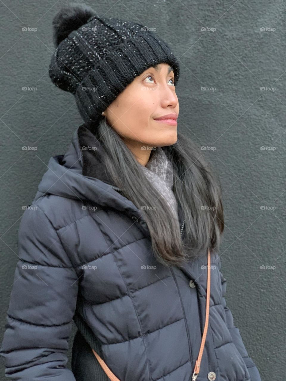 Portrait of a woman looking up against the dark gray background.