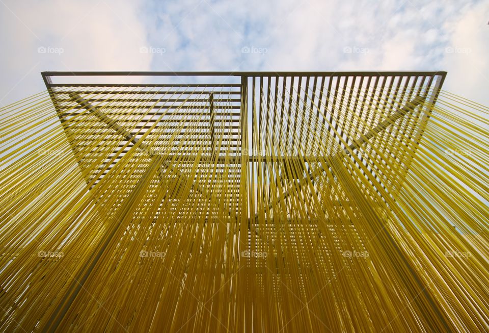 Yellow yarn hanging on metallic structure