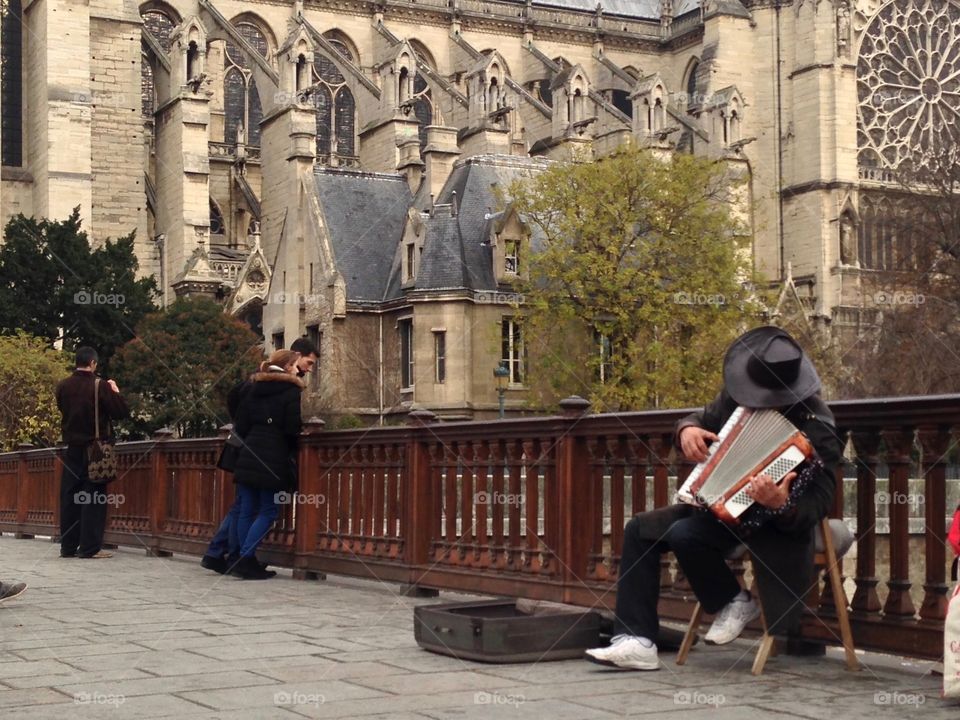 A musician plays the accordion with Parisian flare just outside the Notre Dame
