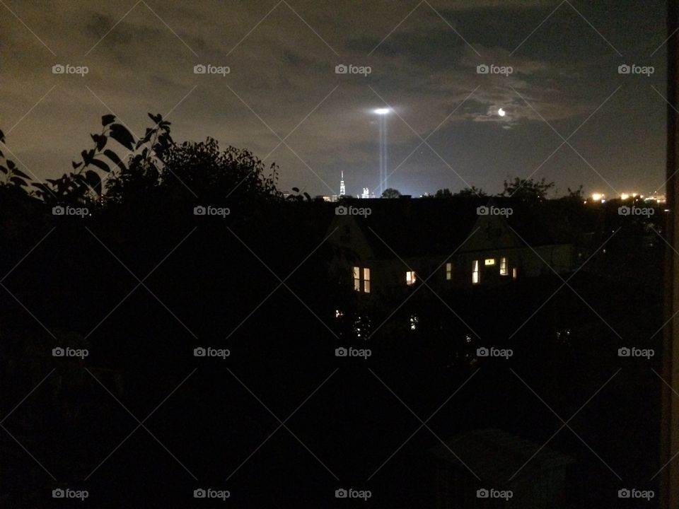 Sept. 11th lights commemorating twin towers viewed from a distance over rooftops in New Jersey