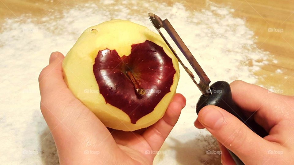 Human's hand peeling apple