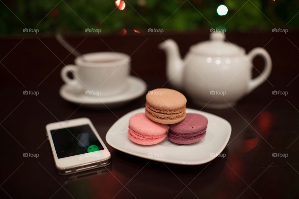 Macaroons with coffee and mobile phone on table