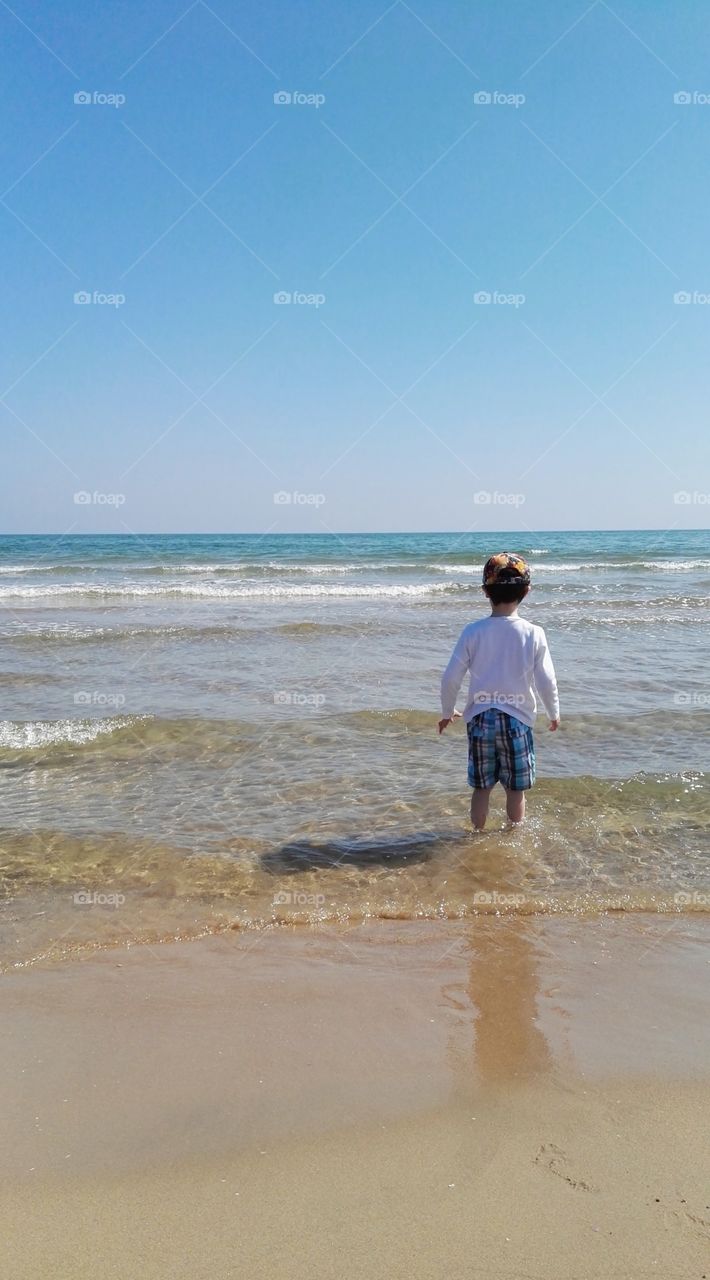 one boy playing with water in the sea