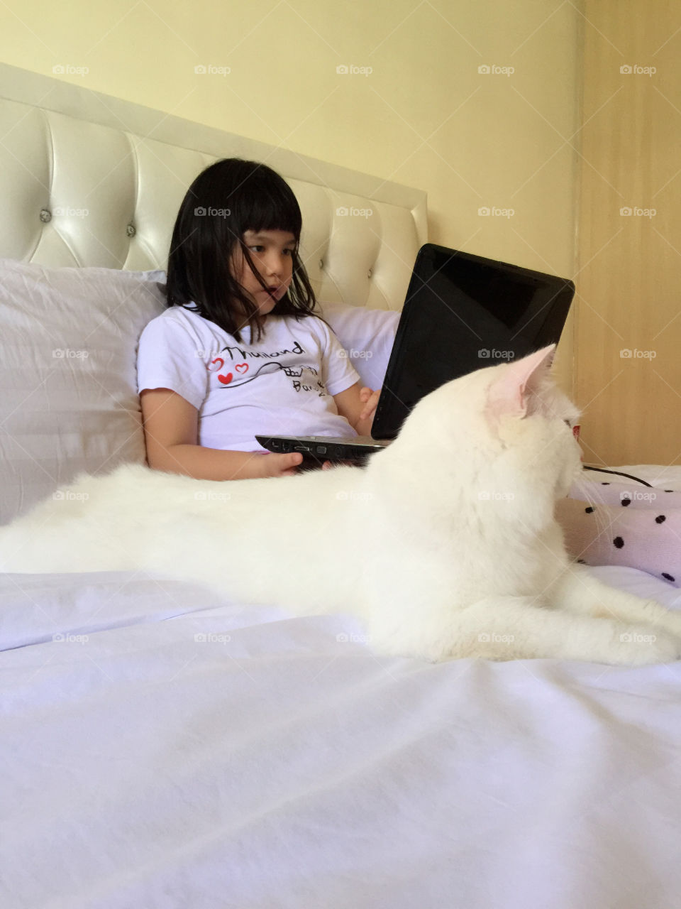 Girl sitting on bed using laptop