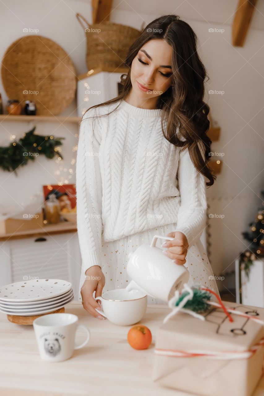Beautiful brunette girl in white clothes prepare to drink tea