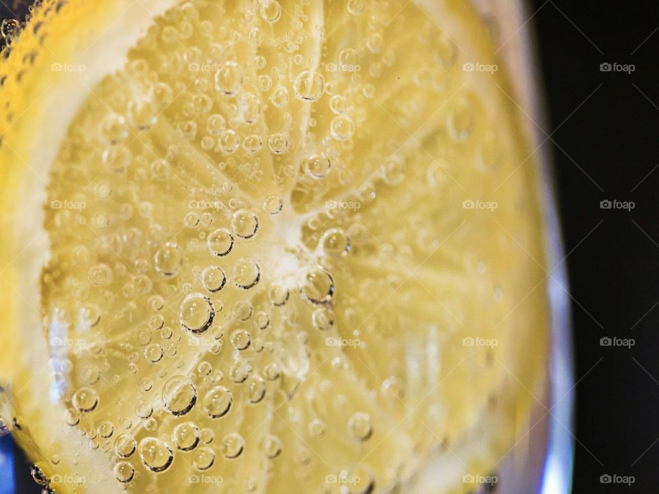 Lemon in sparkling water with bubbles