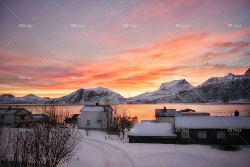 View of snowy mountain and houses near lake