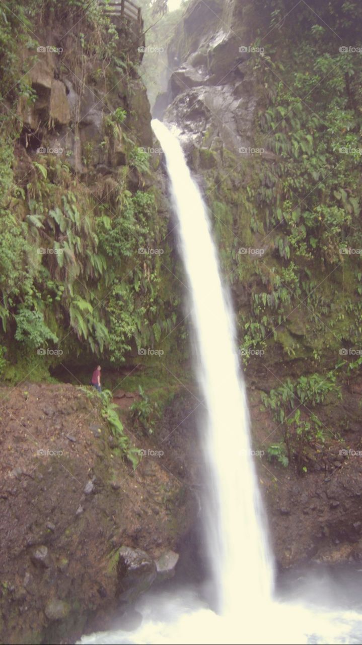 Tall waterfall in Costa Rica, man for scale