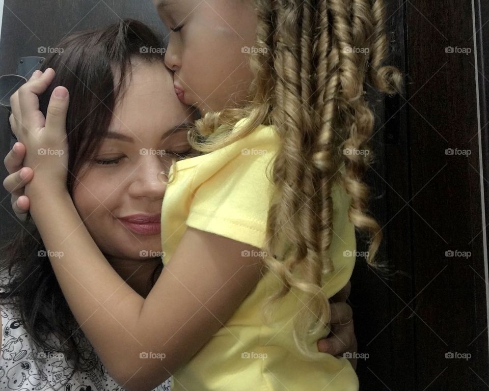 Daughter giving a kiss of love to her mother