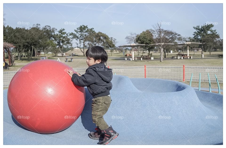 Japanese boy playing with giant ball