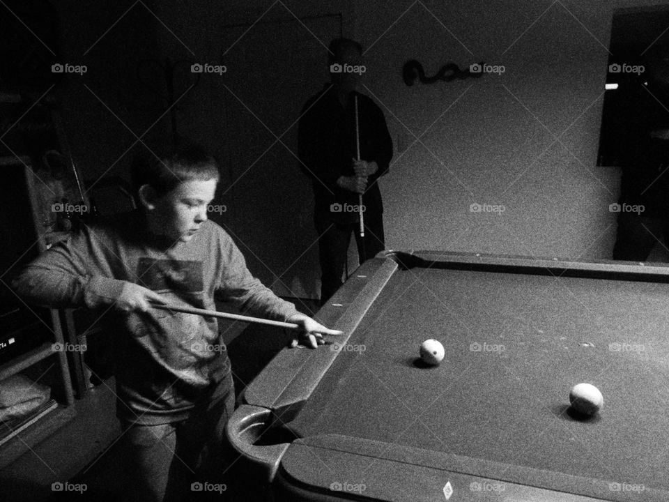 Boy playing billiards