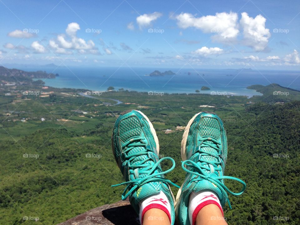 Feet on mountain with green forest