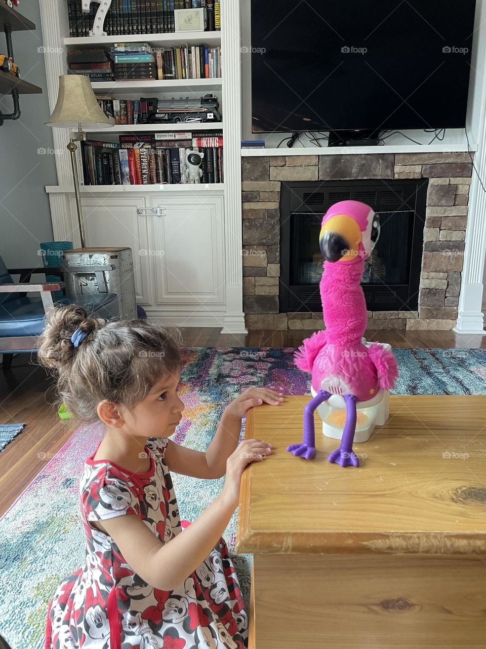 Toddler watches flamingo pooping, flamingo pooping toy for toddlers, little girl loves flamingo toy, flamingo on a potty, silly toy for toddlers 