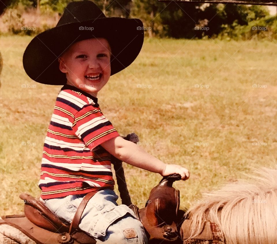 Happy little cowboy at a horse show in South Georgia sporting his black cowboy hat and riding a cool little pony named Snickers. 