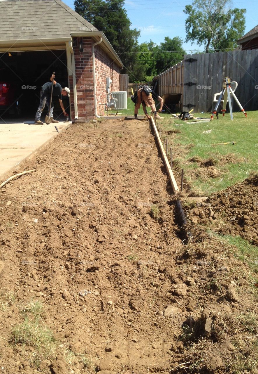 Construction workers creating frame for concrete pour.