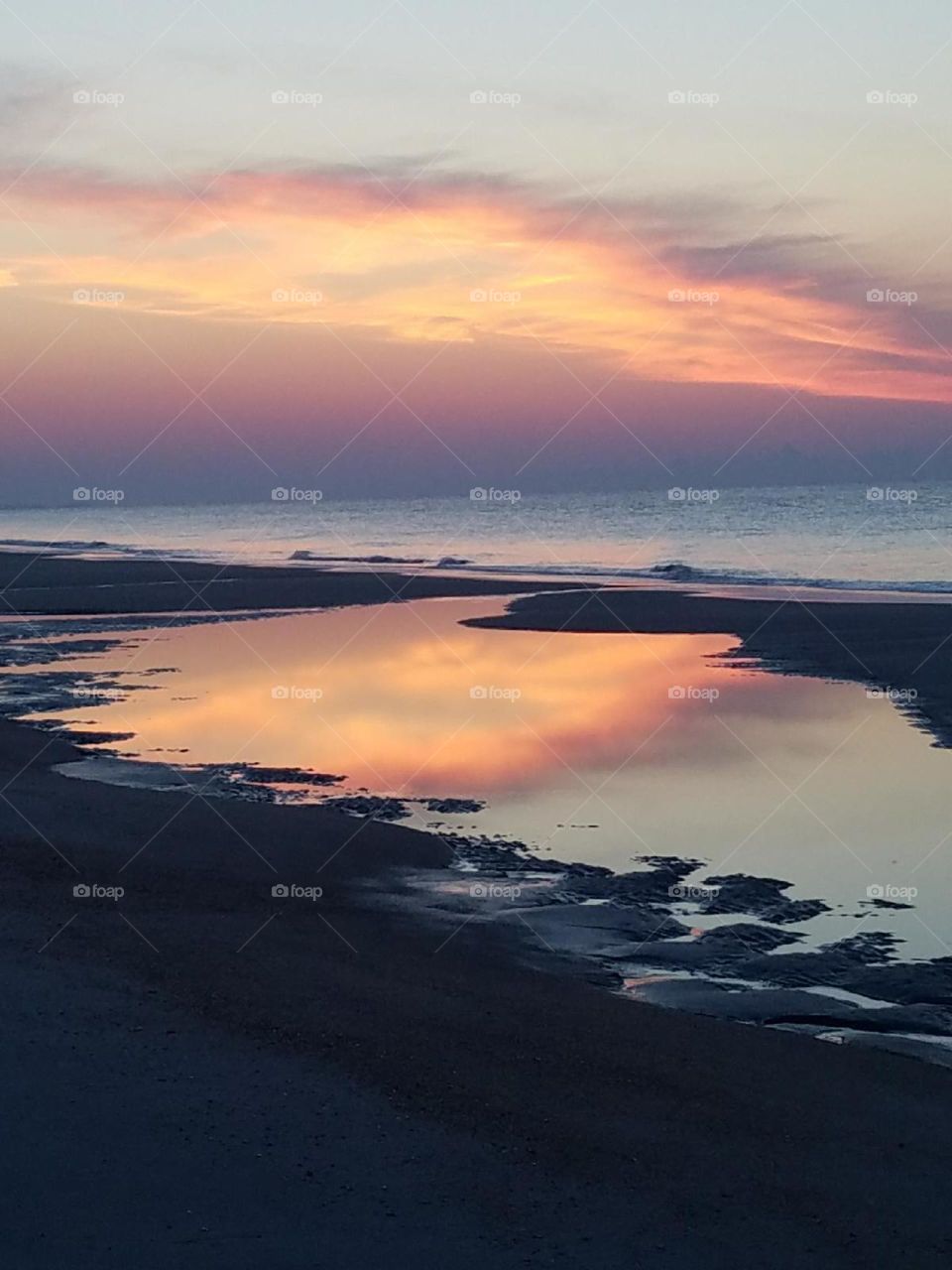 beautiful sunrise reflected over a tide pool on Hilton Head Island, SC
