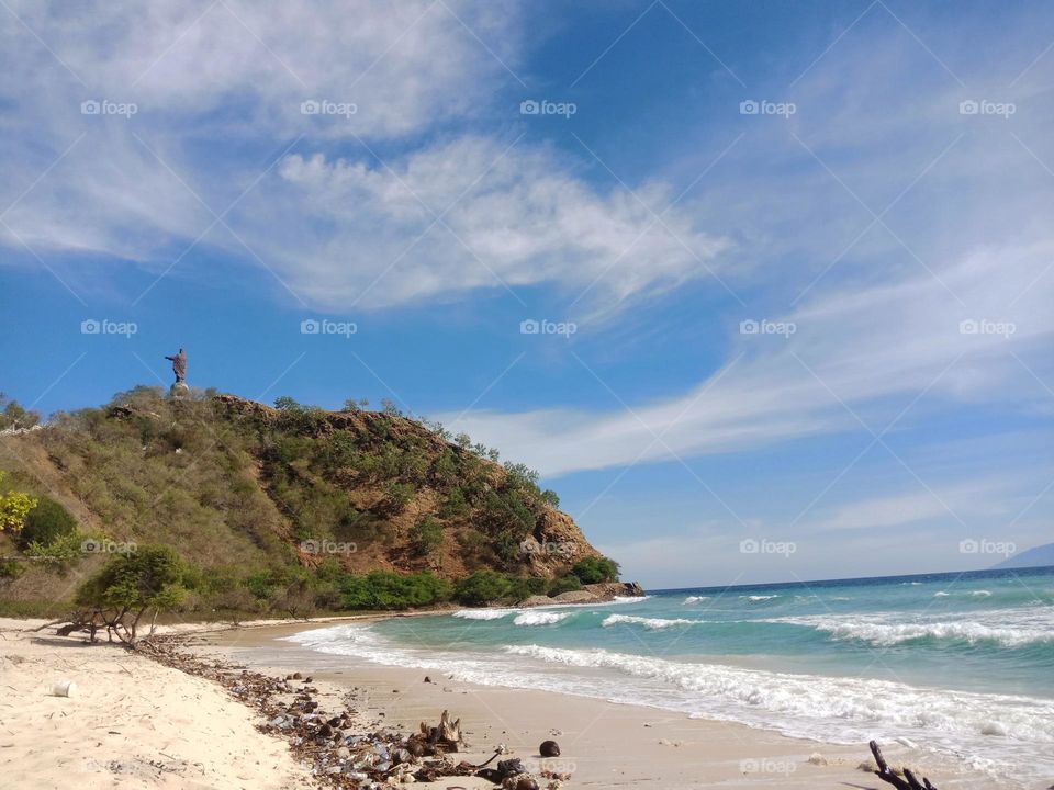 Beautiful sunny day at Dolok Oan beach, Díli, view of Cristo Rei statue