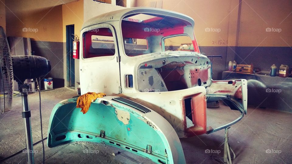 Velha cabine de caminhão em reformas de pinturas em funilaria.