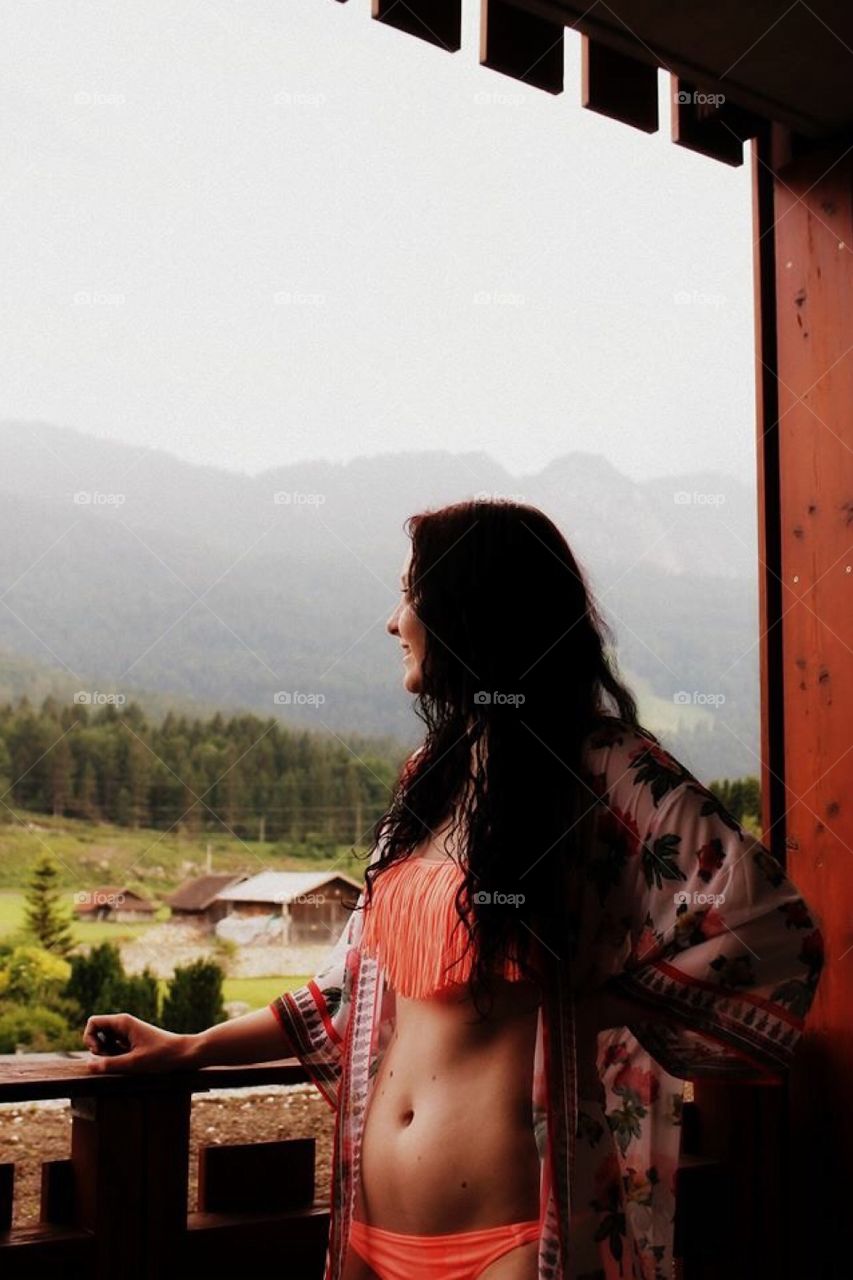 Sensual woman in balcony looking at mountain