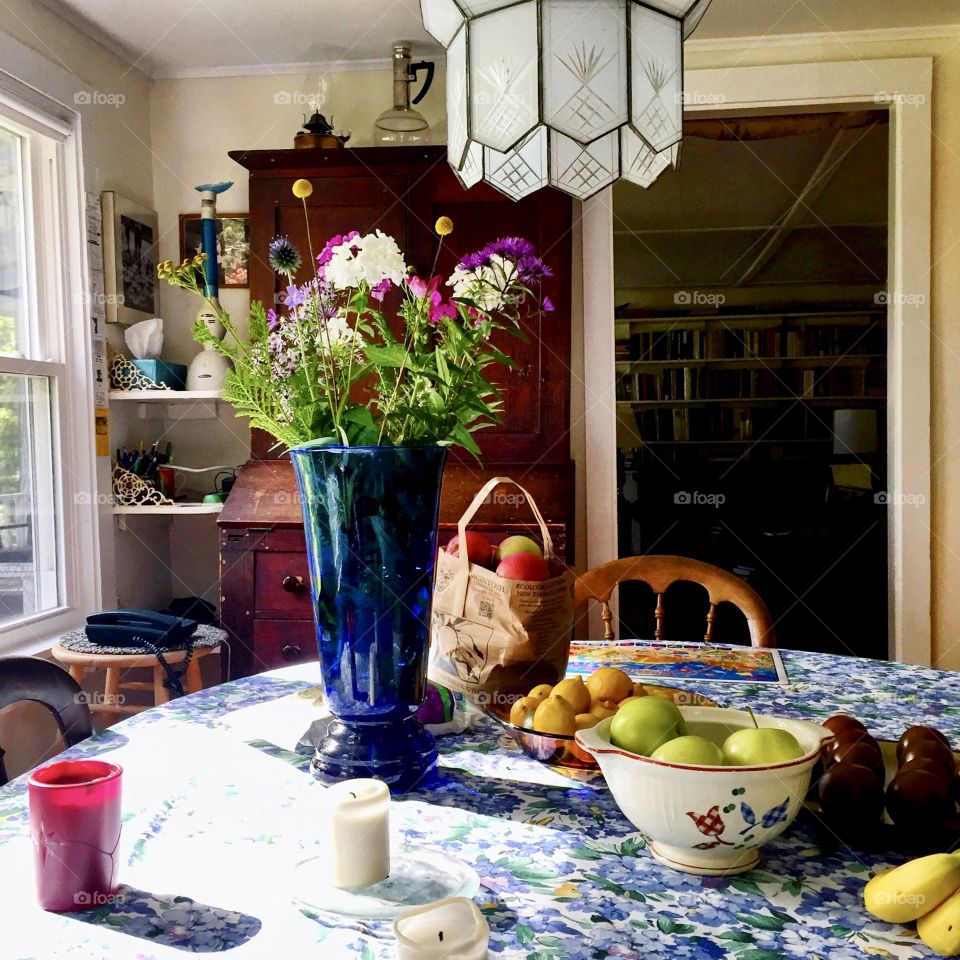 Sun drenched breakfast table with flowers and fruit