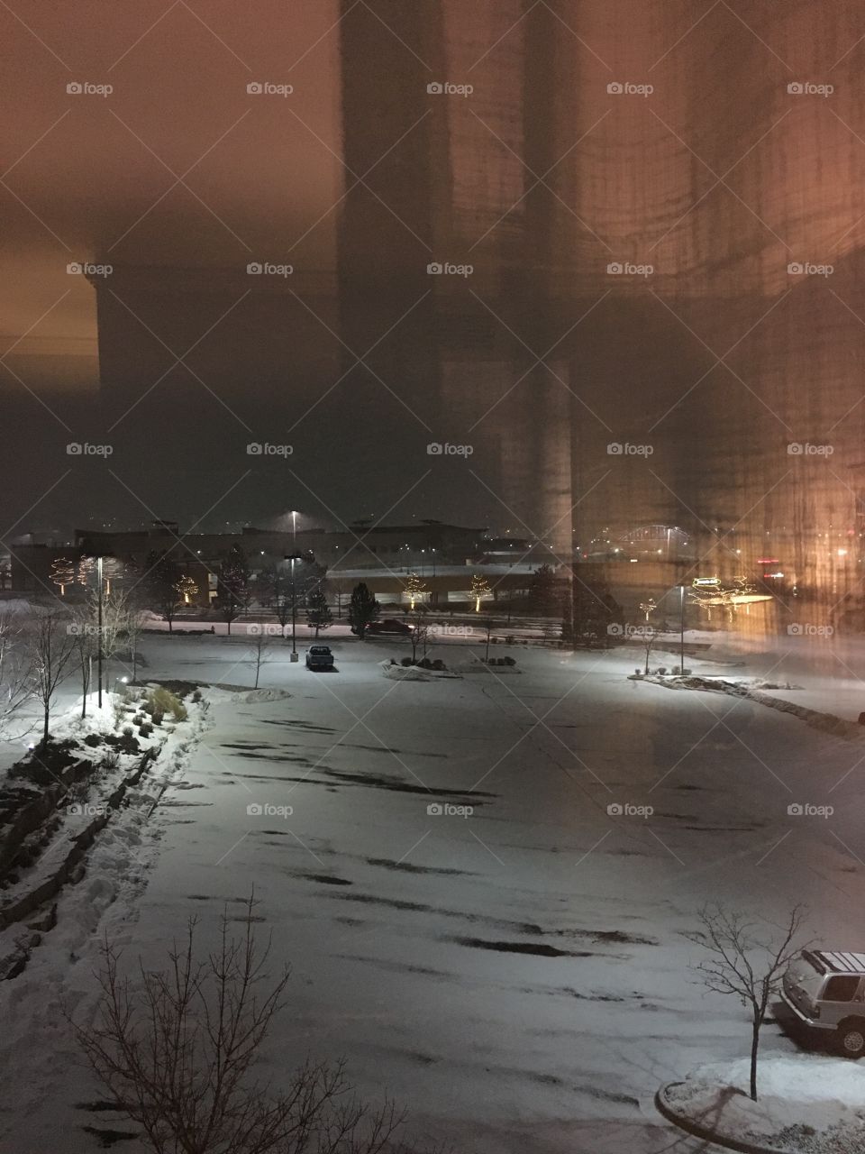 Night time snowfall scene with buildings and soft lights 