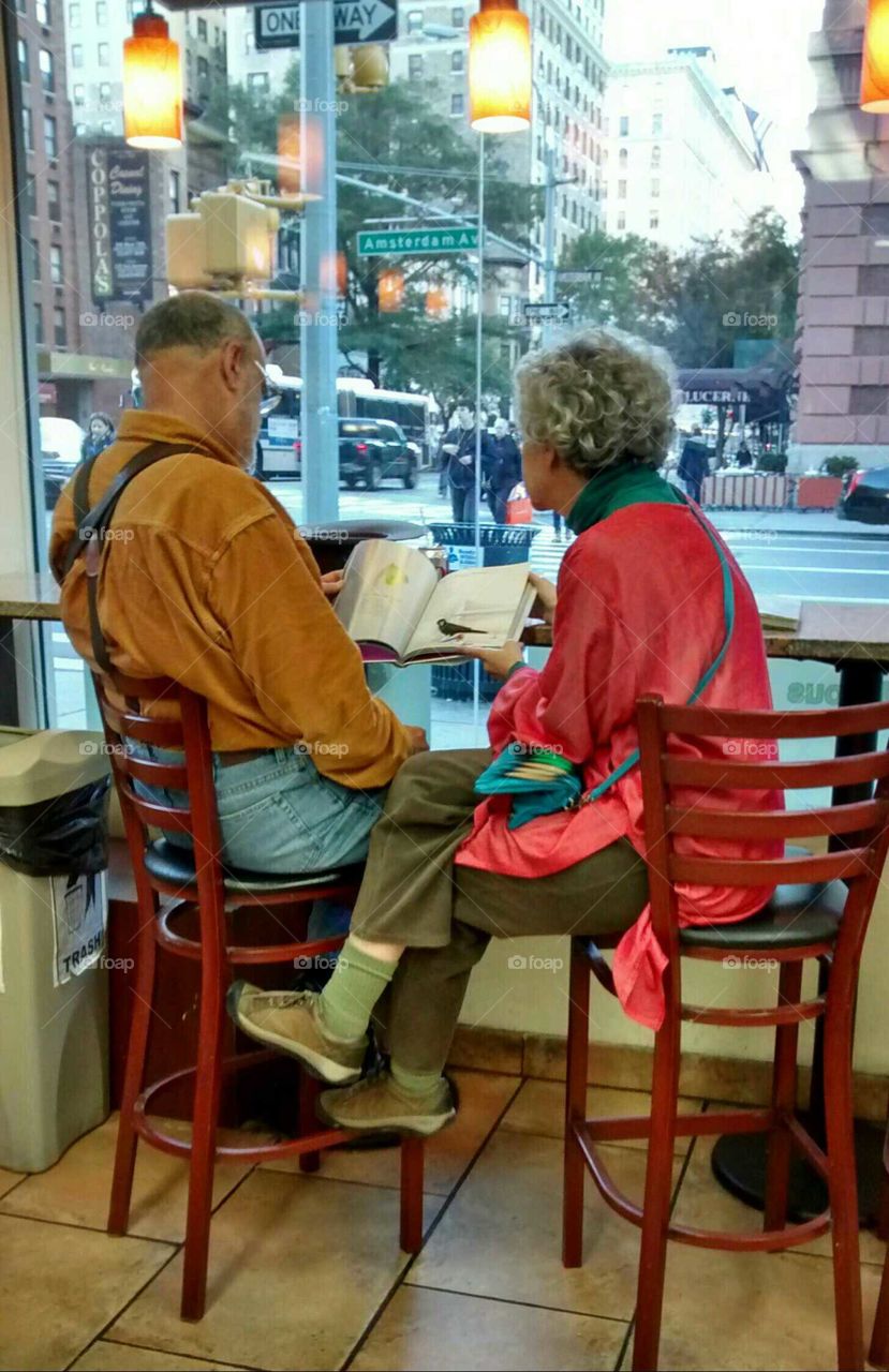Elderly from Behind looking something up in Book