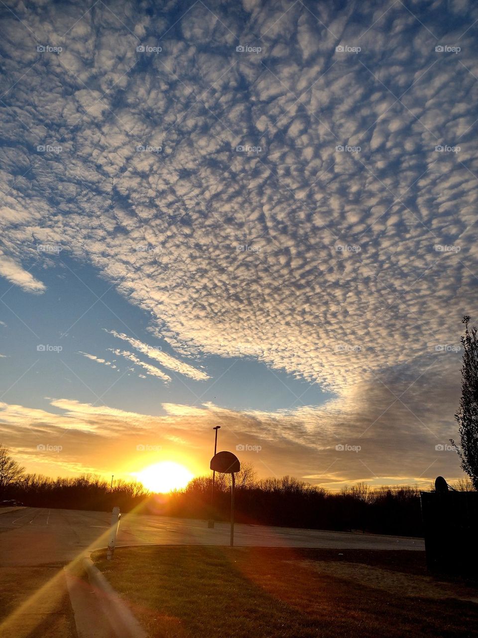 Unfiltered, beautiful, lovely sunset and clouds over a basketball court