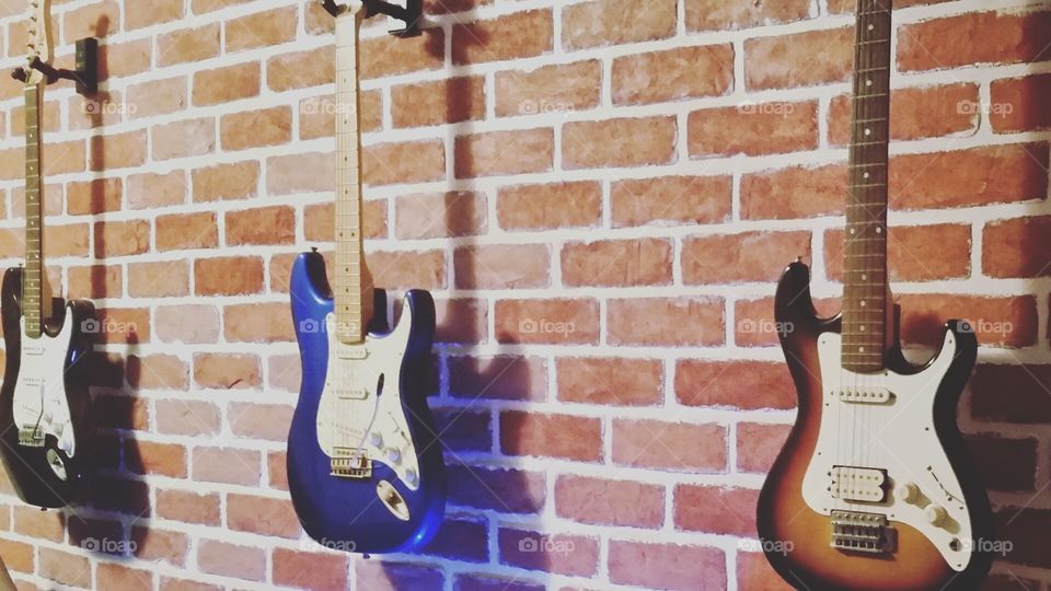 Guitars hanging on a brick wall