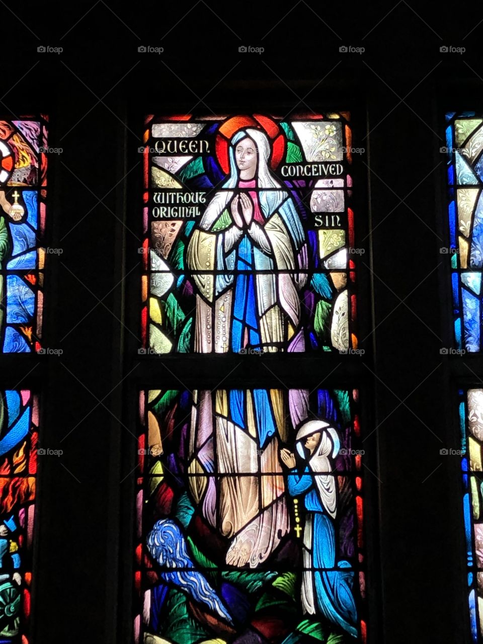 Stained glass image of the Virgin Mary and St. Bernadette 