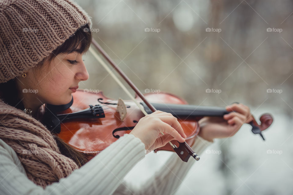 Teenage girl portrait with violin in winter park