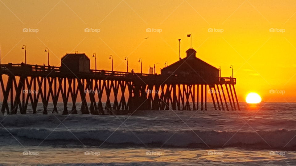 Silhouette of pier on sea during sunset