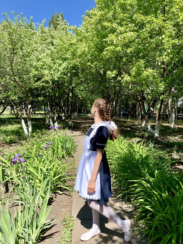 schoolgirl in school garden. Tomorrow the summer holidays begin!