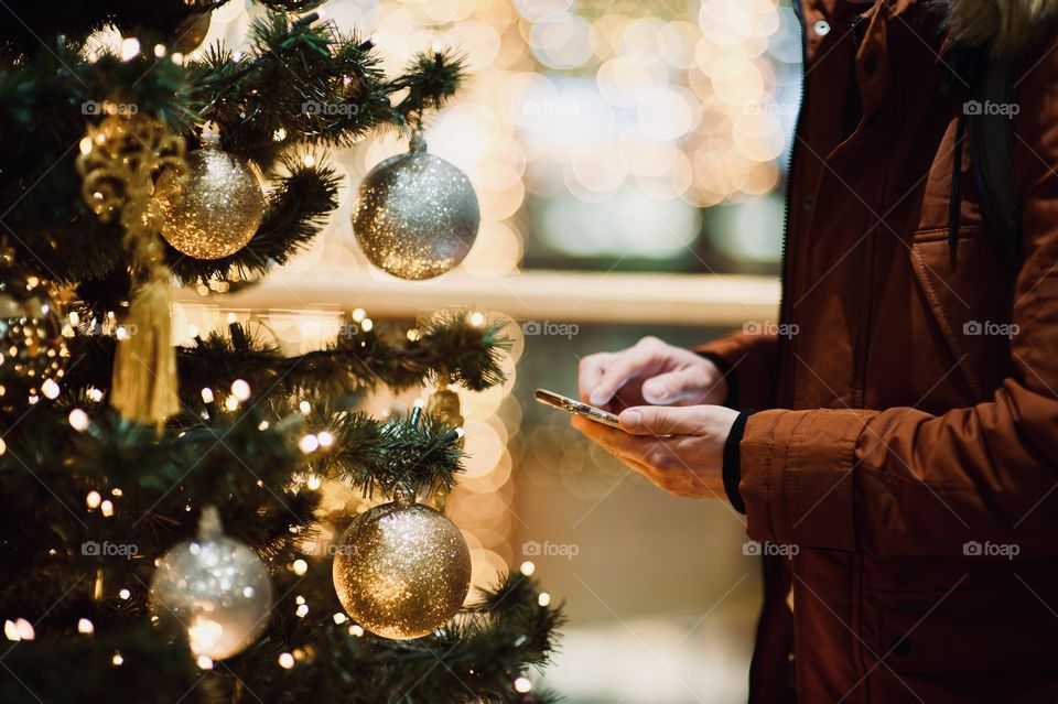 young man dials a message on the phone at christmas