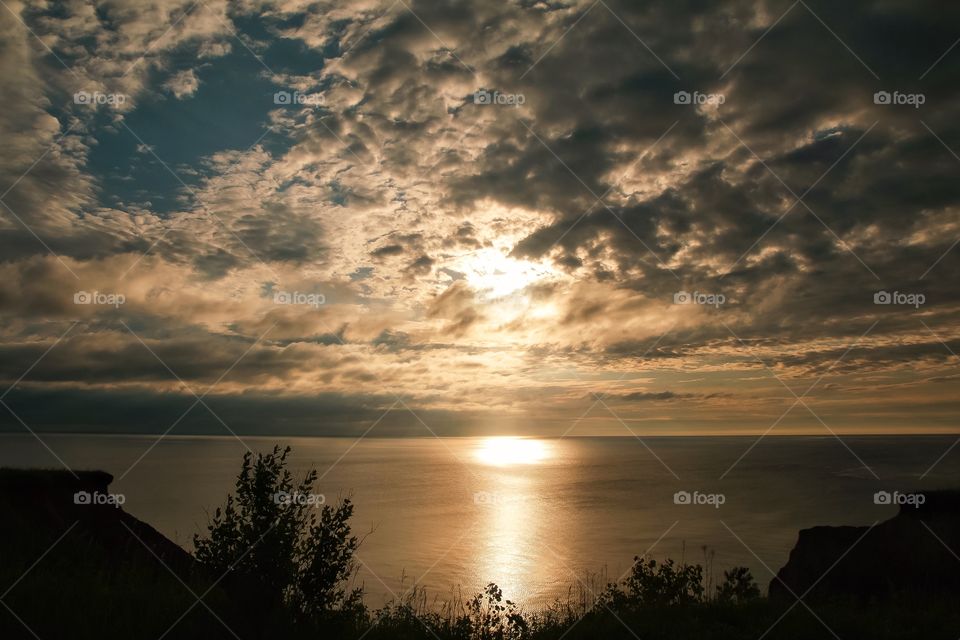 Reflection of sunlight at sea against cloudscape