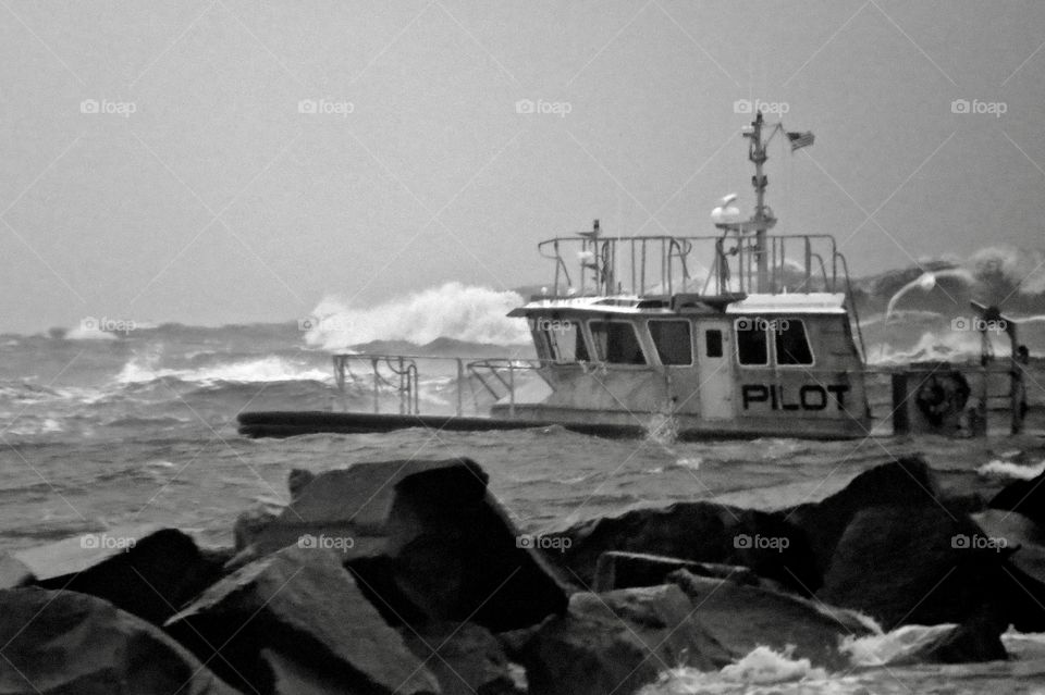 Black and white photo ofboat in huge waves