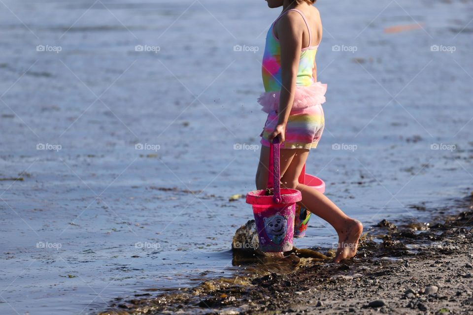 Girl caring pink buckets with water