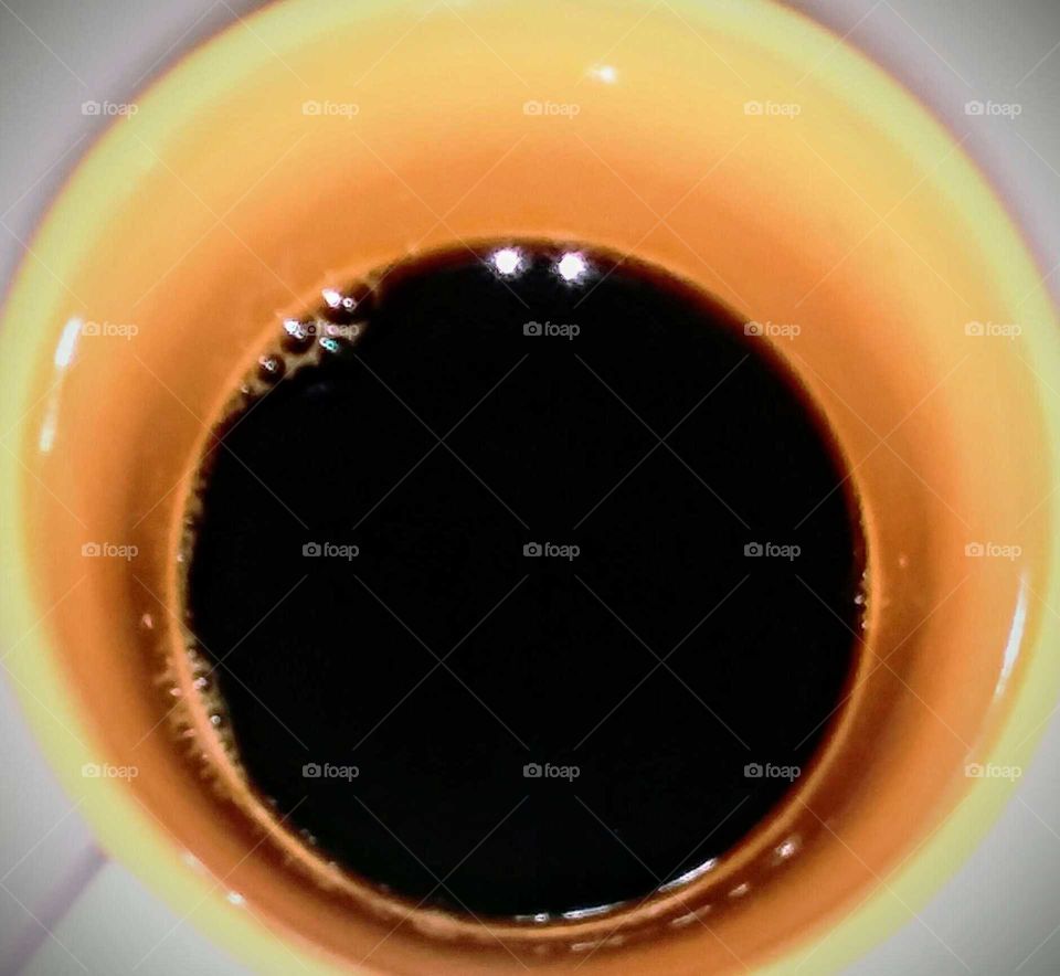 Black Coffee in Yellow Mug (top view, close-up)