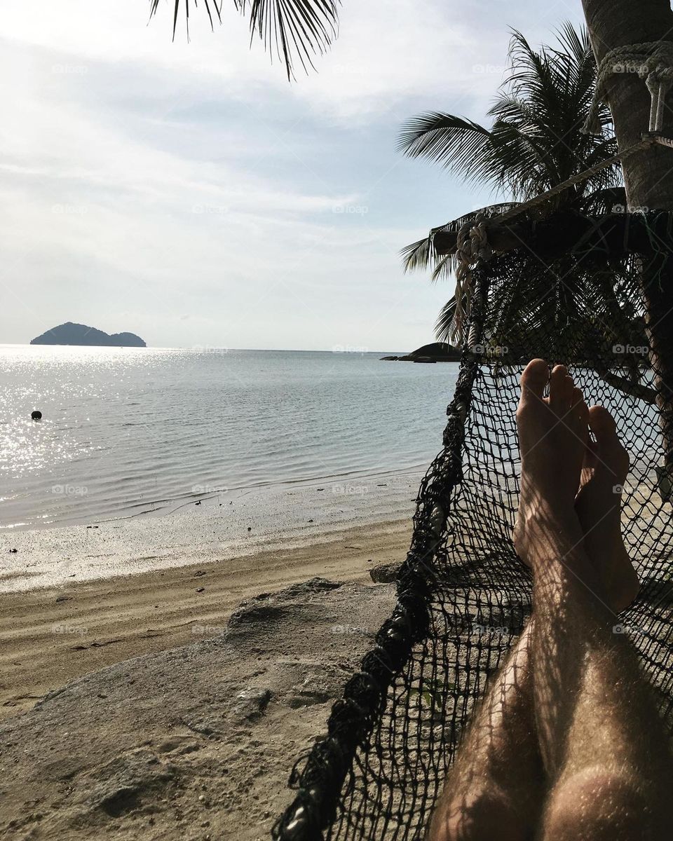 Relaxing by the calm seaside on hammock 