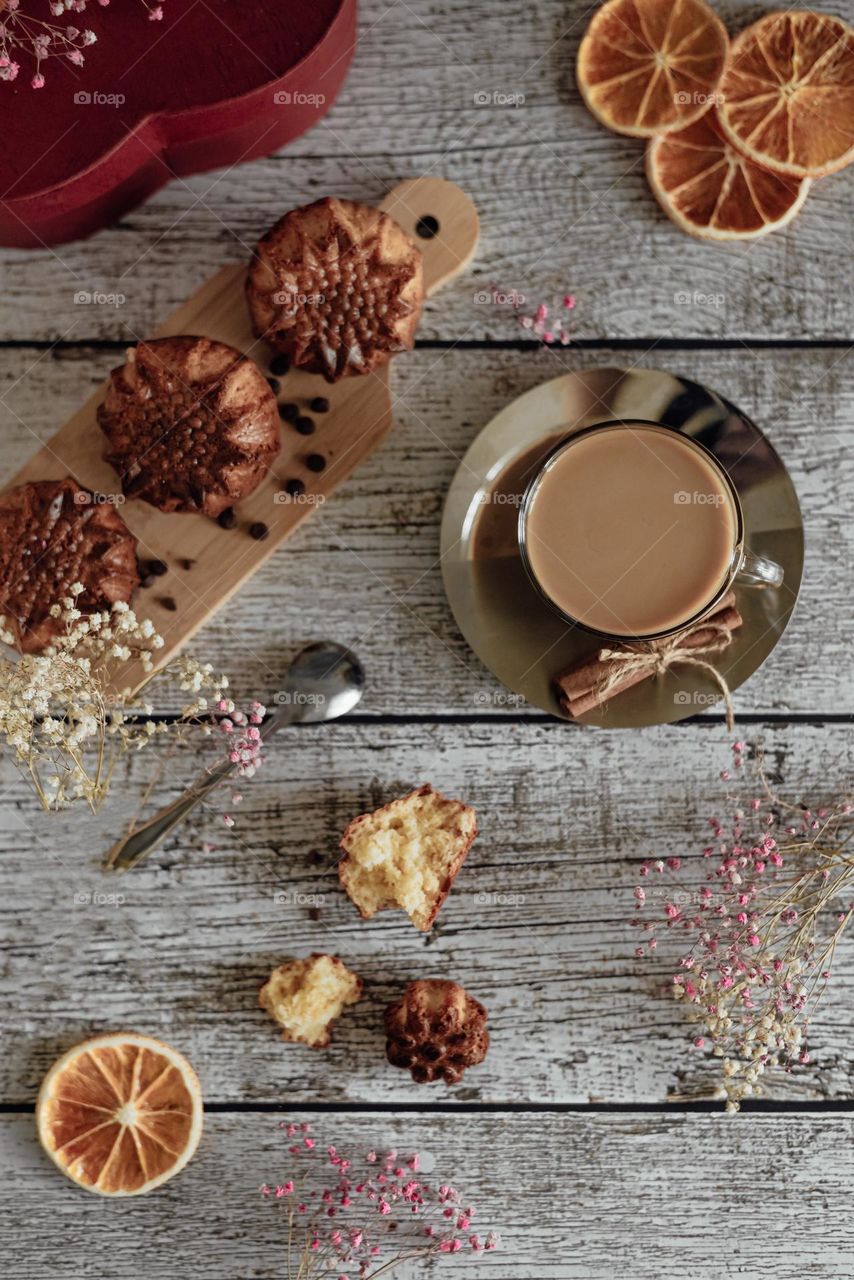 Food still life top view flat lay, coffee with milk and homemade muffins on a light wooden background